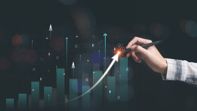 Investor using pen to point interest growth graph ,Financial interest rates ,investment growth percentage and interest on deposits ,an increase in interest rates ,stock market ,Dividends