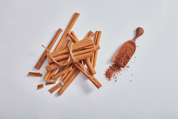 Background minimal style for product of cinnamon extract with cinnamon sticks and powder on white background. Medicinal herbs, cooking spices, cosmetic flavorings