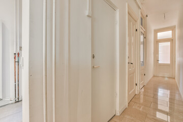 an empty hallway with white walls and door handles on the doors are closed to let light into the...