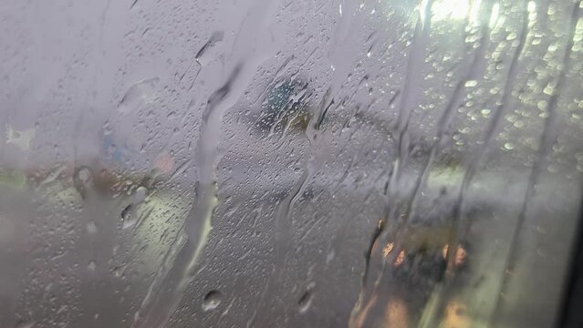 out of focus aircraft wing being deiced viewed through window with flowing glycerin deicing fluid