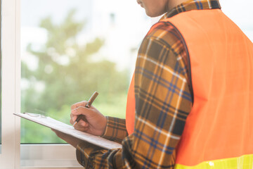 Building inspection, asian contractor young man, male inspecting home, reconstructed construction, renovation or check defect, before finish handing it over to client, customer. Engineering worker.