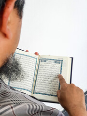 Ramadan Kareem, Eid Mubarak or Islamic concept. The Islamic holy book, Quran or Kuran, on grey background. Arabic words on the book means "Holy Quran".