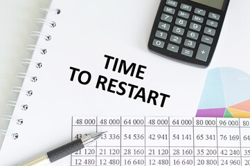 TIME TO RESTART text written on a notebook on write background with chart and keyboard , business concept