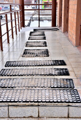 Rubber anti-skid mats lie on the porch on a winter day