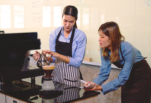 An experienced female barista in uniform will demonstrate how coffee is made and provide a master class. Small business and cafe owner concept