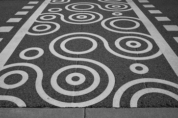 Geometric design on empty pedestrian crossing. An empty pedestrian crossing on the black asphalt road of the street