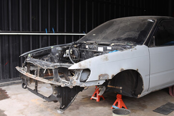 Car engine frameat workshop indoors. Auto body wreck damage work workshop center.