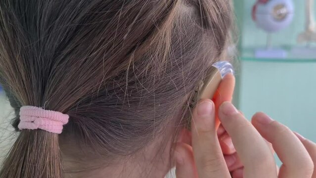 Hearing aid of child and girl suggests hearing aid. Weak hearing in children