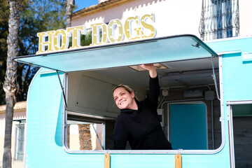 Smiling entrepreneur proudly shows off her hot dog hawker business.
