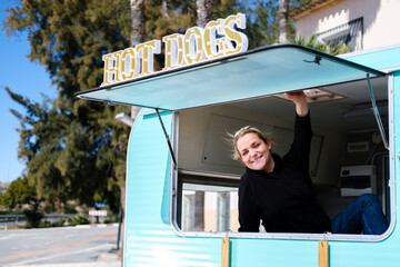 Smiling entrepreneur proudly shows off her hot dog hawker business.
