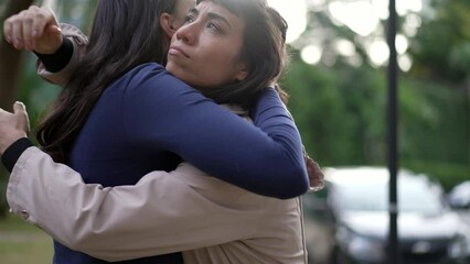 Two friends hugging each other standing outside with EMPATHY and SUPPORT. Friendship concept of female friend EMBRACING suffering person