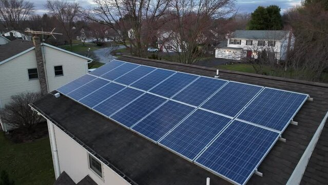 Aerial shot of small solar panel array on home in USA. Photovoltaic array funded by tax credit by government for sustainable energy policy plan.