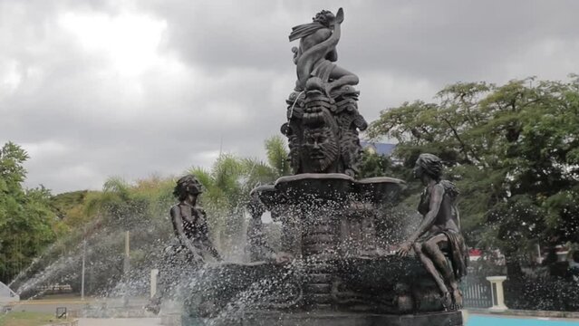 Vista de fuente con estatuas ornamentadas en parque en republica dominicana.
