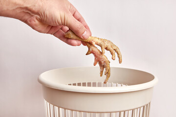 Chicken feet are thrown into the trash.Disposal and recycling of food waste. - obrazy, fototapety, plakaty