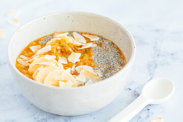 Chia pudding with passion fruit, coconut and coconut yogurt in bowl. Healthy vegan recipe.