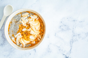 Chia pudding with passion fruit, coconut and coconut yogurt in bowl. Healthy vegan recipe.