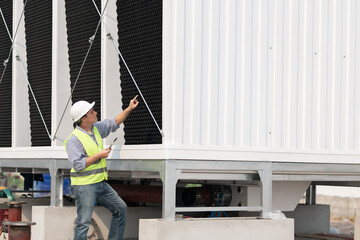 Industry engineer under checking the industry cooling tower air conditioner is water cooling tower air chiller HVAC of large industrial building to control air system.
