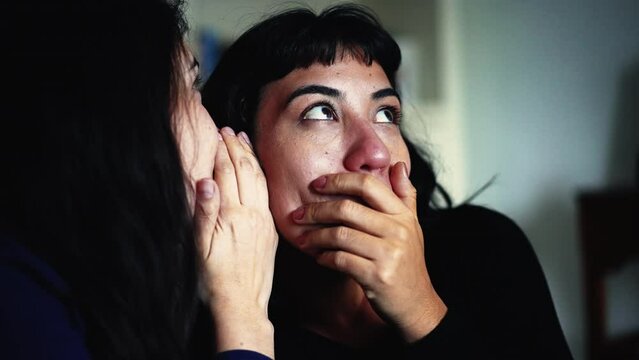 Women sharing rumor whispering SECRET to friend ear. Person reaction with SHOCK and UNBELIEF to NEWS