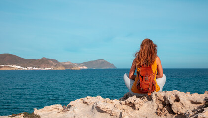 woman breathing fresh air on the rocky beach- relaxation,