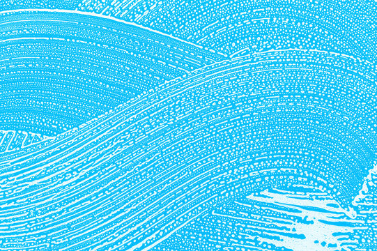 soap foam on window glass, blue background, spring cleaning, abstract pattern