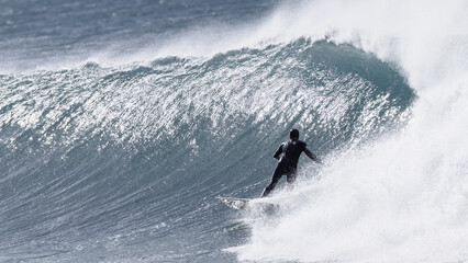Surfer Surfing Unrecognizable Riding Cold Windy Ocean Wave .
