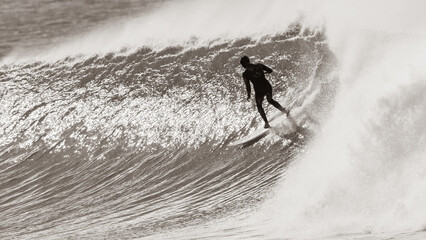 Surfer Surfing Unrecognizable Riding Cold Ocean Wave In Vintage Sepia Retro Tone Photograph.