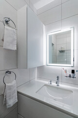 Modern bathroom in white washer and large mirror with backlight