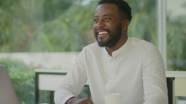 Black entrepreneur in formal outfit shaking hands with business partner after making a deal on meeting in outdoor cafe