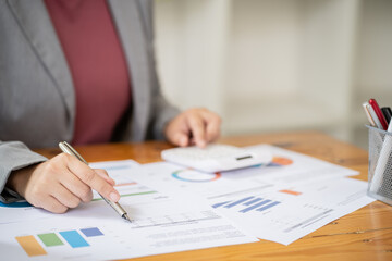 Businesswoman Accountant analyzing investment charts Invoice and pressing calculator buttons over documents. Accounting Bookkeeper Clerk Bank Advisor And Auditor Concept