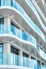 Light blue glass fences on fashionable hotel terraces at popular resort. Stylish multistory...