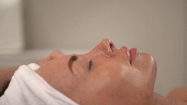master woman performs the procedure using a microcurrent apparatus for facial skin. close-up face. real time video. High quality Full HD video recording