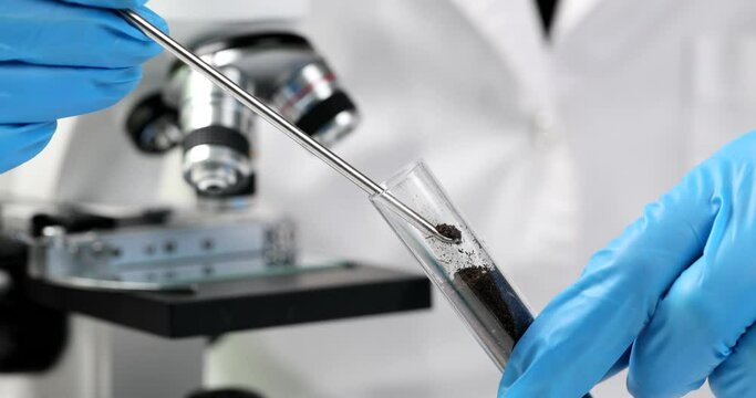 Scientist biologist geologist takes sample of soil in test tube