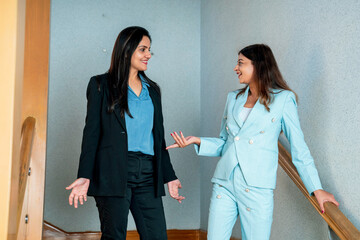 Two indian Corporate woman talking each other some subject at office