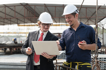 Two foreman builder discussing precast concrete wall structure quality at construction site. Group of construction supervisor working at construction site