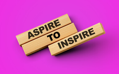 Aspire To Inspire Text On Wooden Blocks Isolated On Magenta Background, 3d illustration
