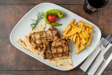 Spicy grilled chicken on a white porcelain plate