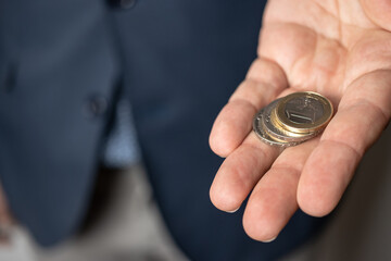 Plakat Man holds euro coins in his hand, currency of the European Union