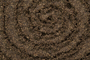 Spiral poured ground black pepper background. Dry seasoning pepper. Spices and herbs for cooking, pepper powder