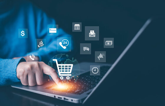 Businessman using a laptop with online shopping concept, marketplace website with virtual interface of online Shopping cart part of the network, Online shopping business with selecting shopping cart.