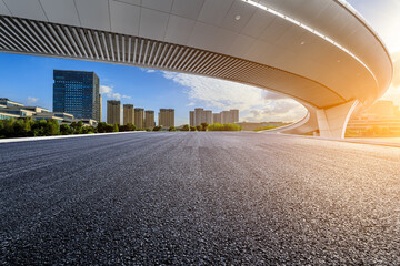 Asphalt road and bridge with modern city skyline at sunset in Ningbo, Zhejiang Province, China.