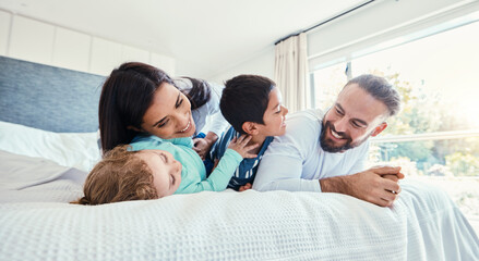 Happy, love and family being playful on the bed together in the bedroom of their modern house. Happiness, excited and children having fun, playing and bonding with their parents in a room at home.