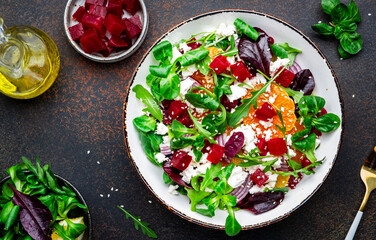 Beet, cheese and orange healthy salad with arugula, lamb lettuce, red onion, walnut and tangerine,...