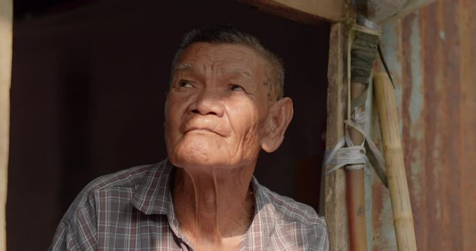 The Asian male farmer who is a poor elderly native looked up at the sky as though something had happened. Used in humanity, documentary, lonely person, environment, concepts, or movies.