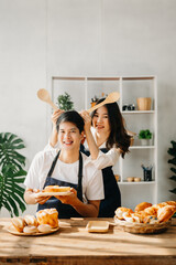 Image of newlywed couple cooking at home. Asia young couple cooking together with Bread and fruit in cozy kitchen