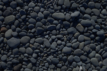 Fototapeta na wymiar Black pebbles background texture. Horizontal wallpaper