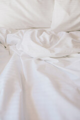 Bed and white linens in a hotel room.