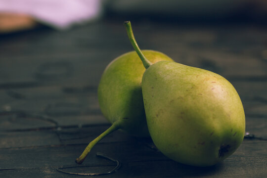 pears to eat cut with a wooden knife and on a brown background