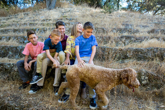 Boy tries to stop dog from running away during a family portrait