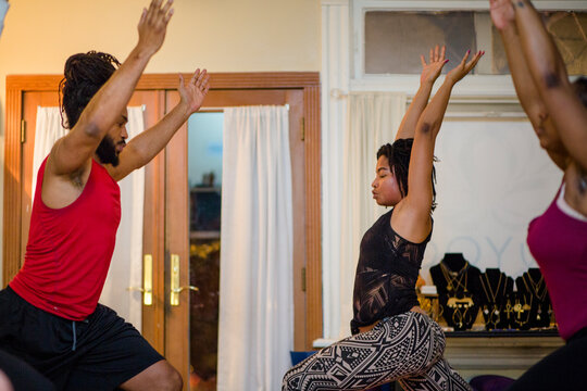 A female yoga instructor leads students in relaxation techniques