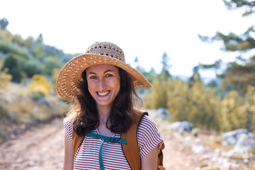 Portrait of a woman with a backpack and a straw hat